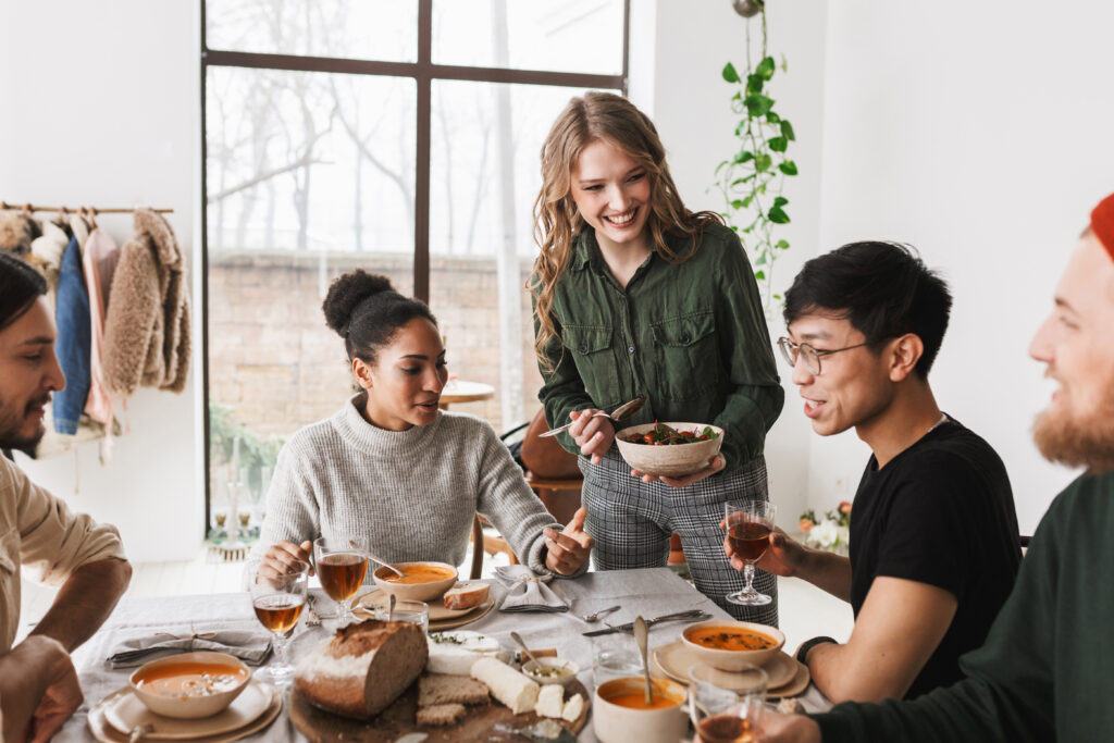 Group of people sat round a table having a meal 