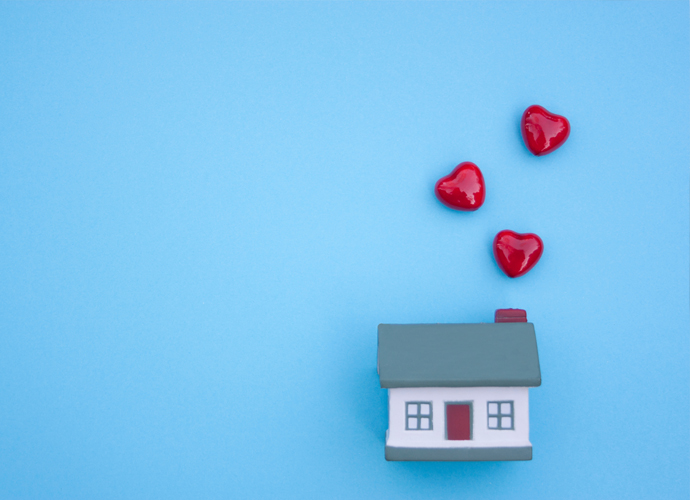 Model house on a blue background with red love hearts