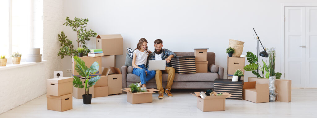 a happy young married couple moves to new apartment