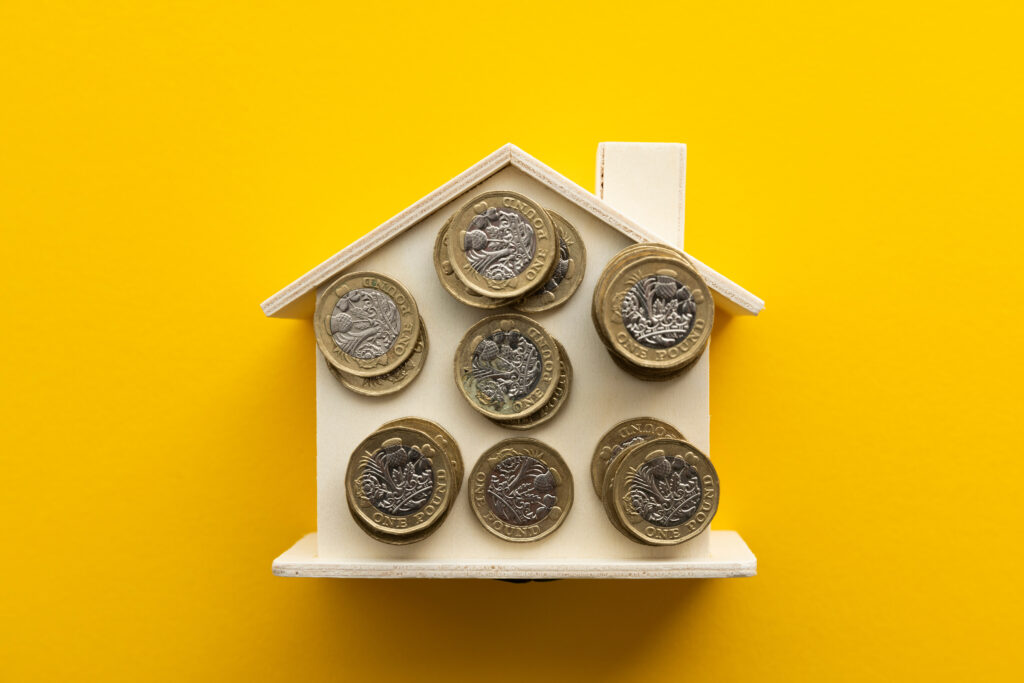 United Kingdom pound coins on a wooden house
