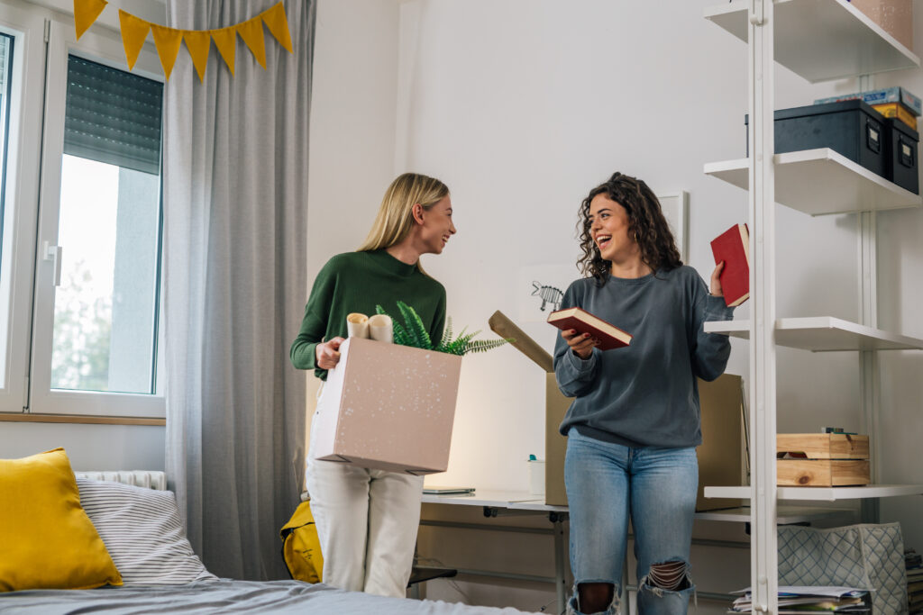 female college student move in dorm. they are talking in the room