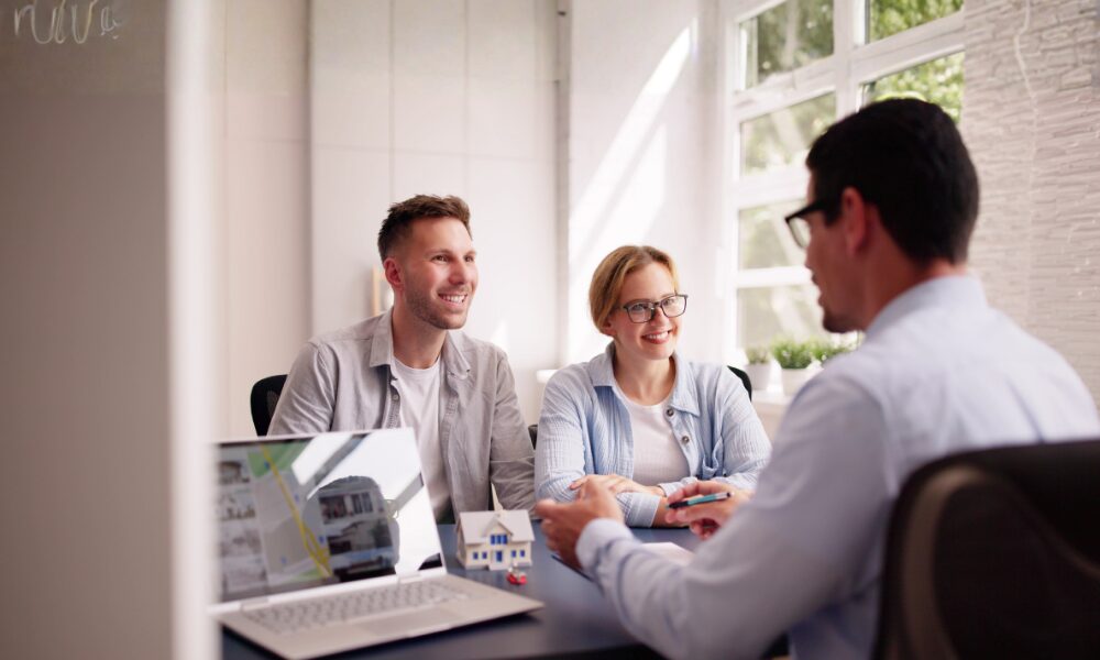 Homeowners meeting with an estate agent to discuss downsizing and property value in Stoneygate Leicester.