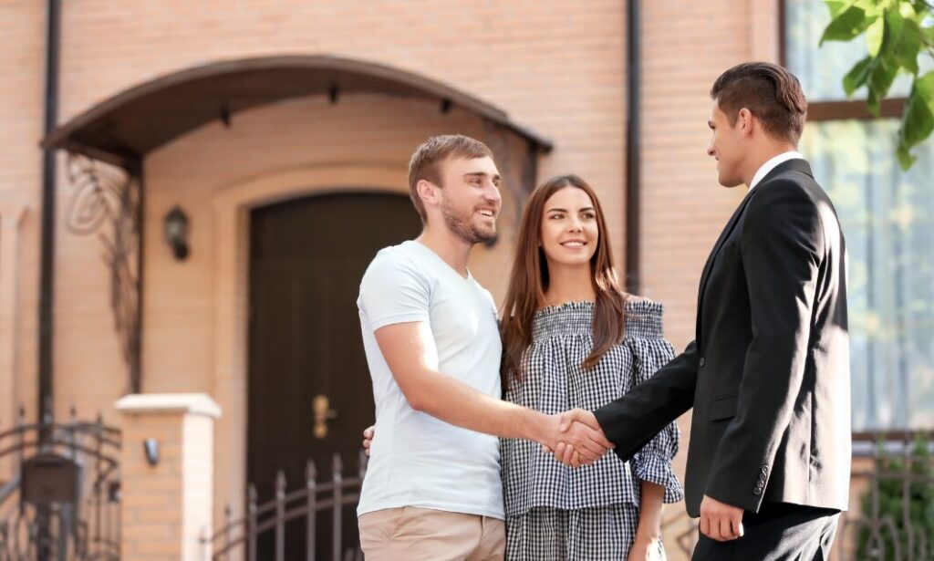Couple shaking hands with estate agent outside a house in Colehill Wimborne after property viewing