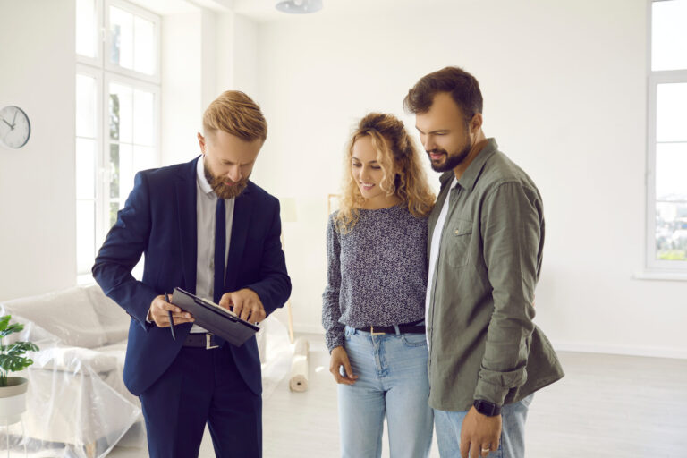 Wimborne letting agent discussing rental property details and tenancy paperwork with prospective tenants in a bright apartment.