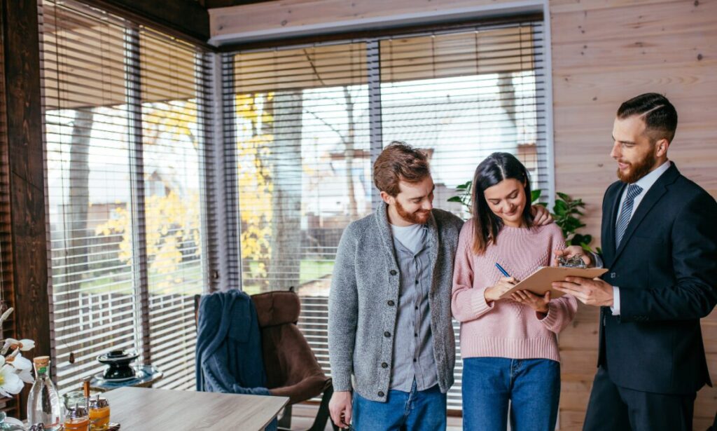 Estate agent guiding a couple through property paperwork, representing Wimborne Local Plan changes and BH21 house price demand.