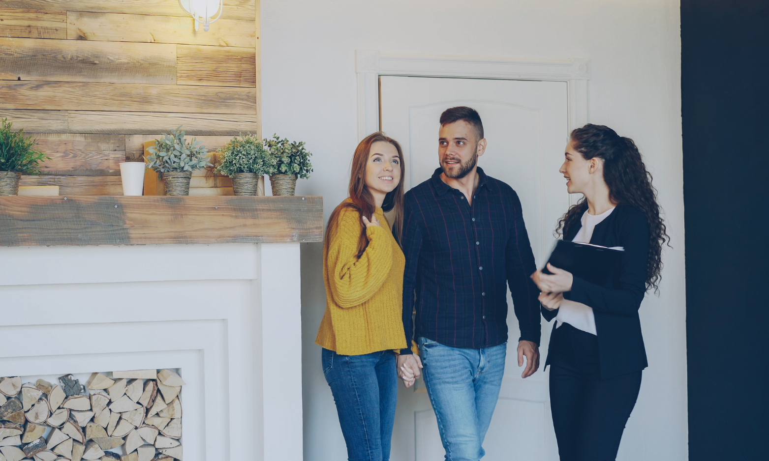 Couple speaking with an estate agent while viewing the interior of a bright, well-presented home.