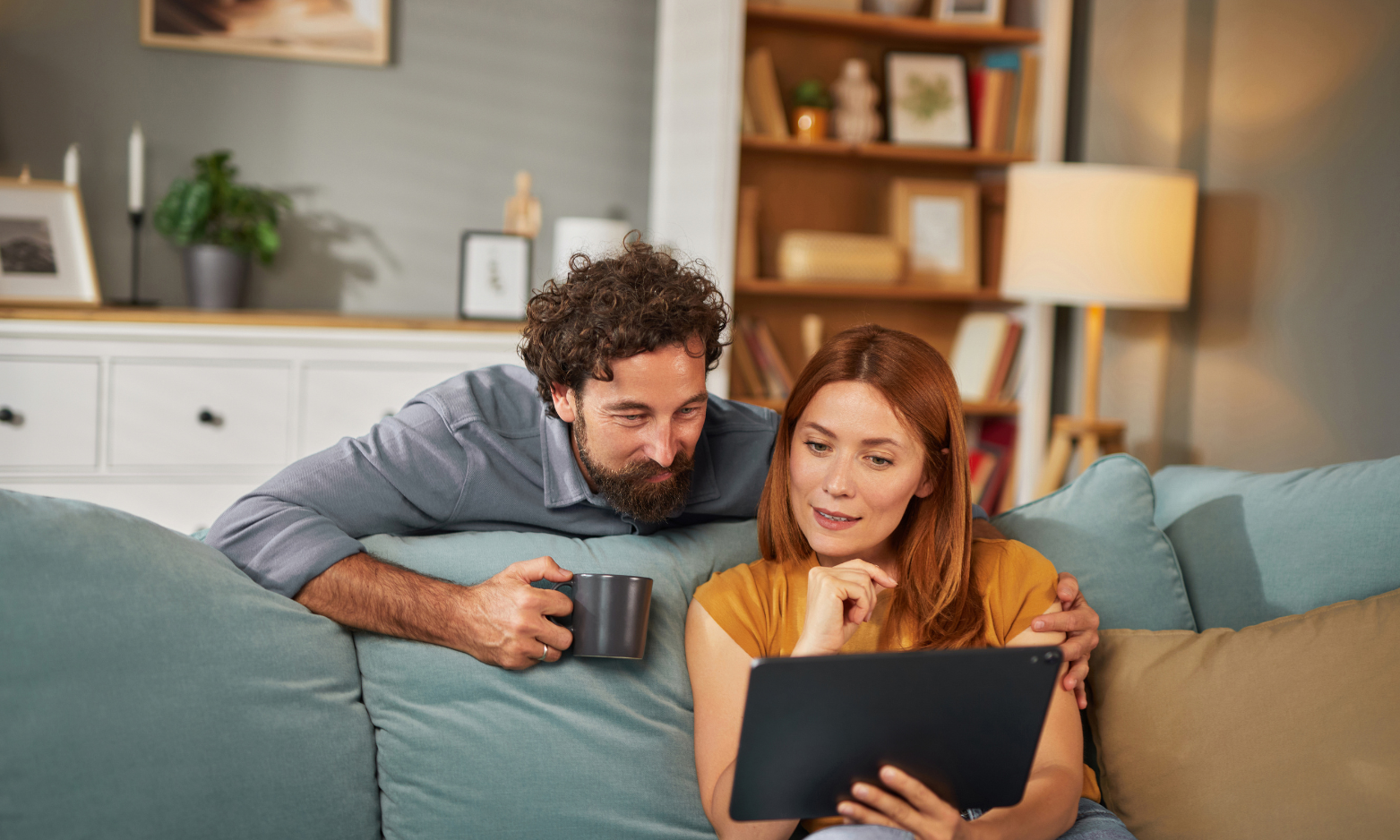 Couple reviewing property information on a tablet at home while preparing for upcoming landlord compliance requirements.