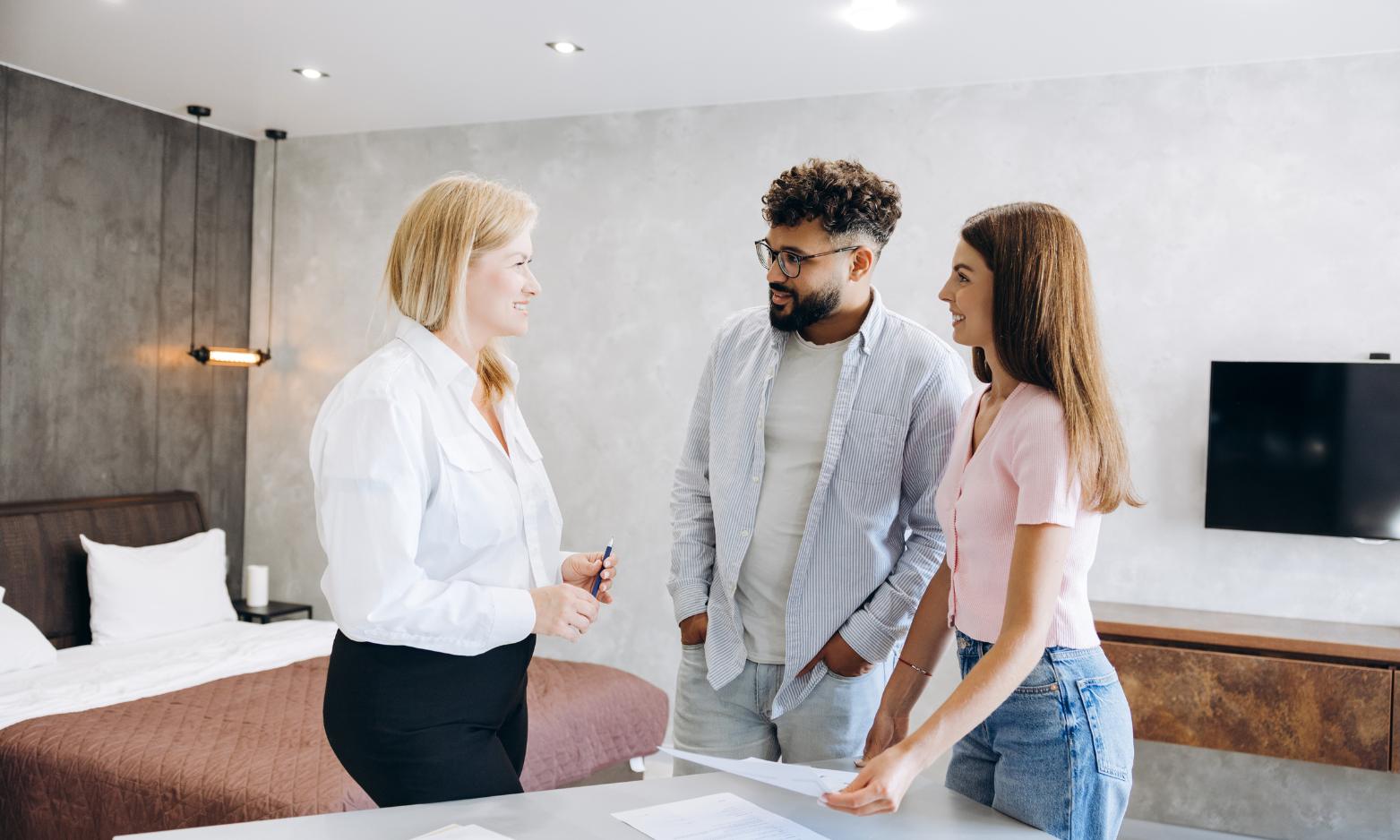 Couple discussing a property with an estate agent while searching for a home in the LE19 area.
