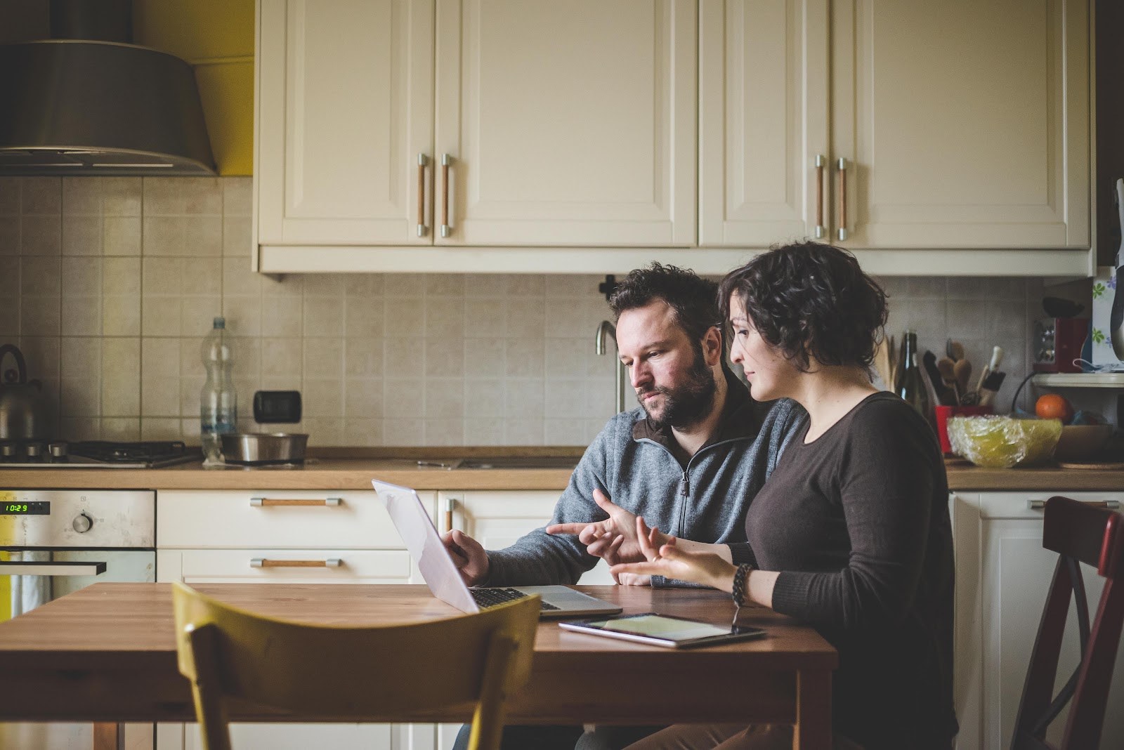 Couple at a table using a laptop to research homes and planning changes in Leicester's LE6, LE8 and LE9 postcodes