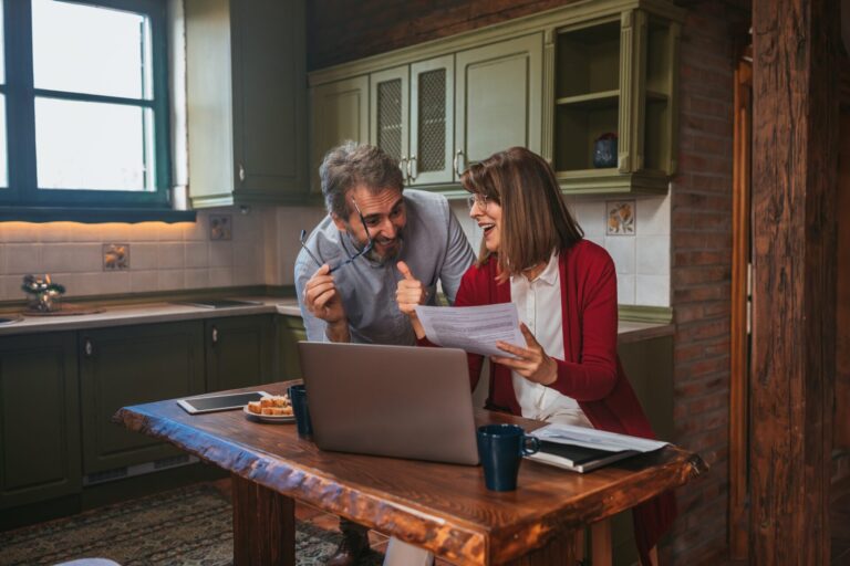Wimborne landlords at their kitchen table with a laptop, registering their rental on the national property portal