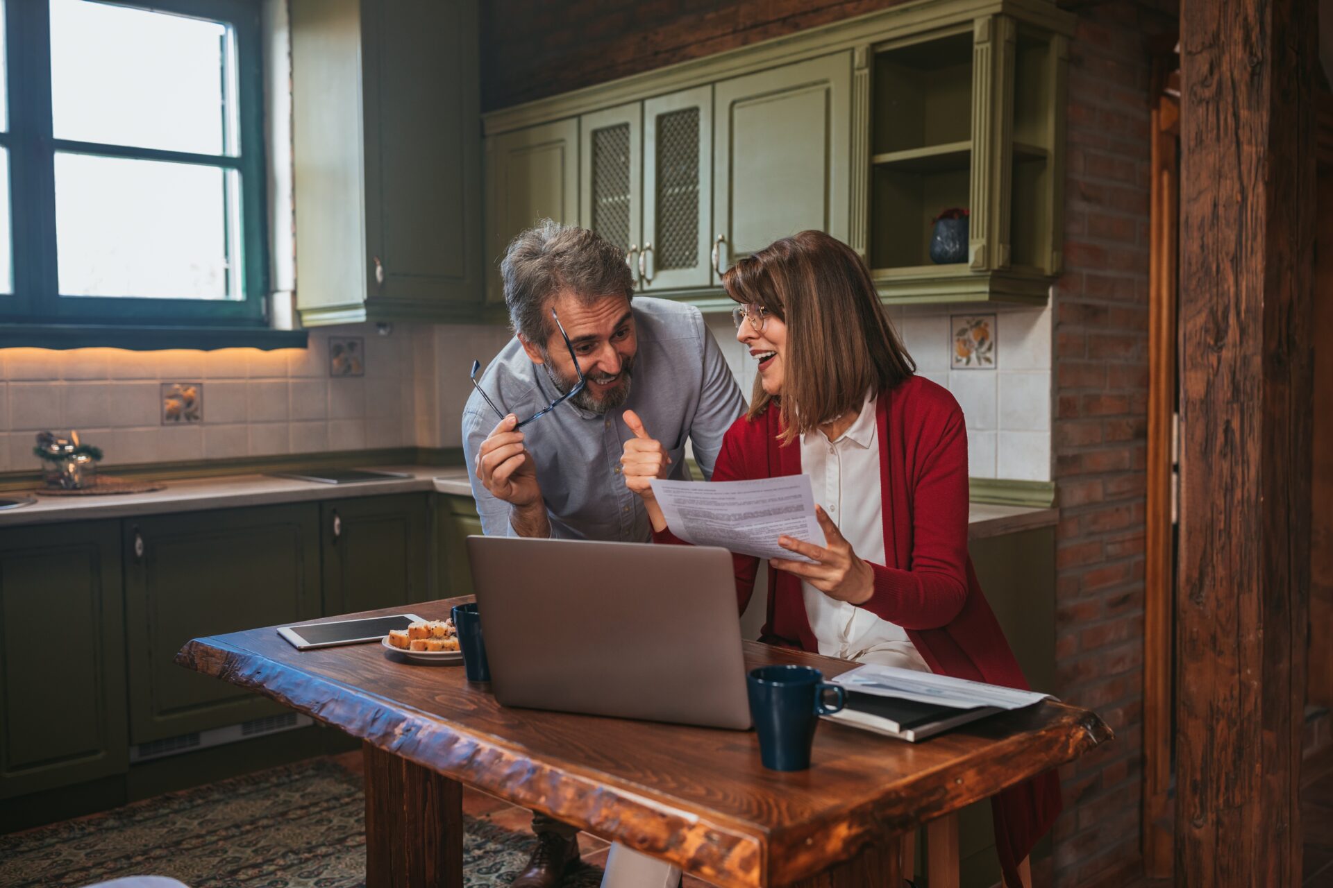 Wimborne landlords at their kitchen table with a laptop, registering their rental on the national property portal